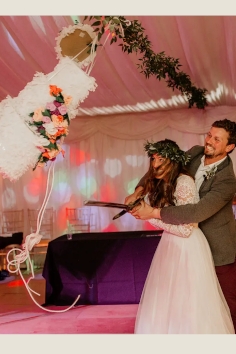 Wedding couple hitting a cakep piñata