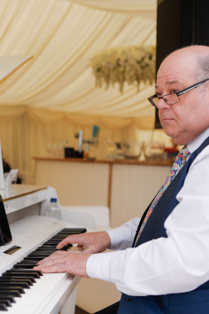 Roger Miners on his baby grand piano in a wedding marquee